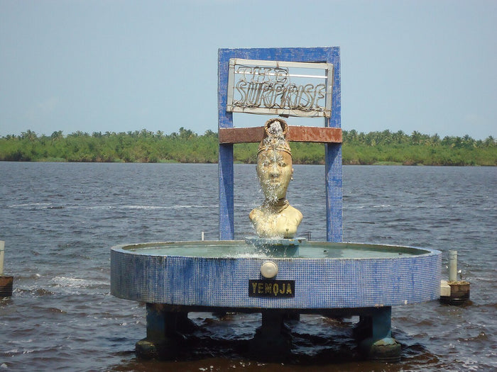 Yemoja statue rising from the water at Badagry, Nigeria, honouring the river and sea mother in her Yoruba homeland.