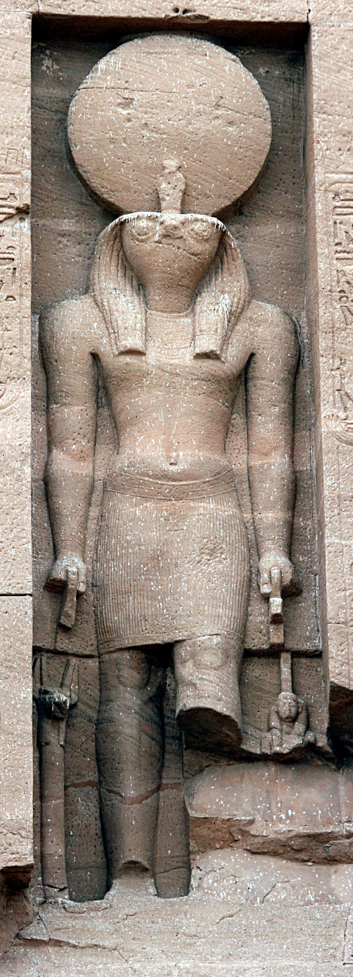 Falcon-headed Ra with sun disc and uraeus, carved in a niche on the Abu Simbel temple façade.