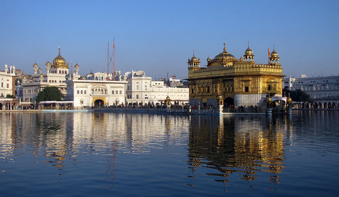 Harmandir Sahib (Golden Temple), Amritsar, reflected in the Sarovar at dusk. Sikhism's central shrine, where the Ik Onkar message is recited.