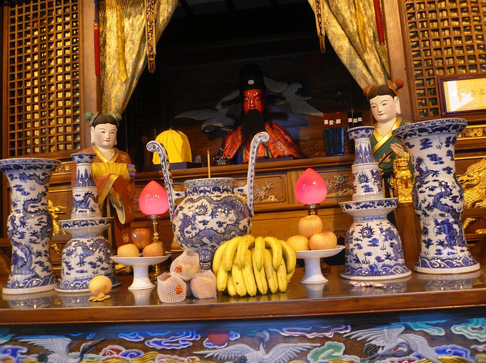 Altar of the Shanghai City God Temple: blue-and-white ritual vessels, offerings and attendant figures before the enthroned deity.