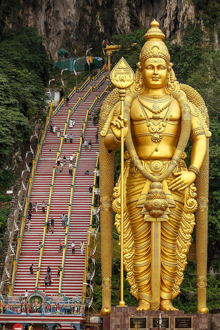 Giant golden Murugan statue at Batu Caves, Selangor, Malaysia, with the stairway to the cave temple behind.