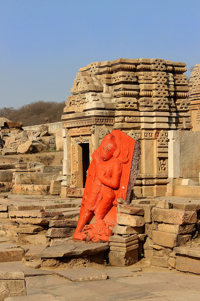 Orange-painted Hanuman relief among the ruined medieval Batesara temples, Morena, showing the sindoor-coloured worship of the deity.