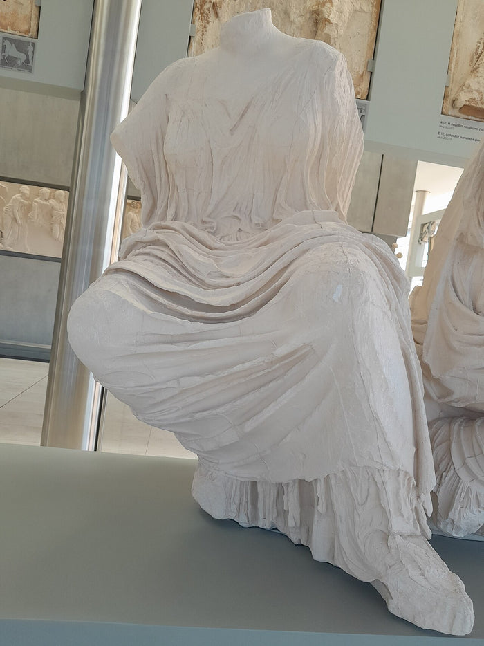 Plaster cast of the seated figure identified as Hestia from the Parthenon's east pediment, with deeply carved drapery.