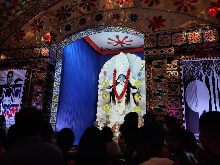Kali Puja pandal at Siliguri, 2023: a white Kali image with red garland, worshipped by crowds.