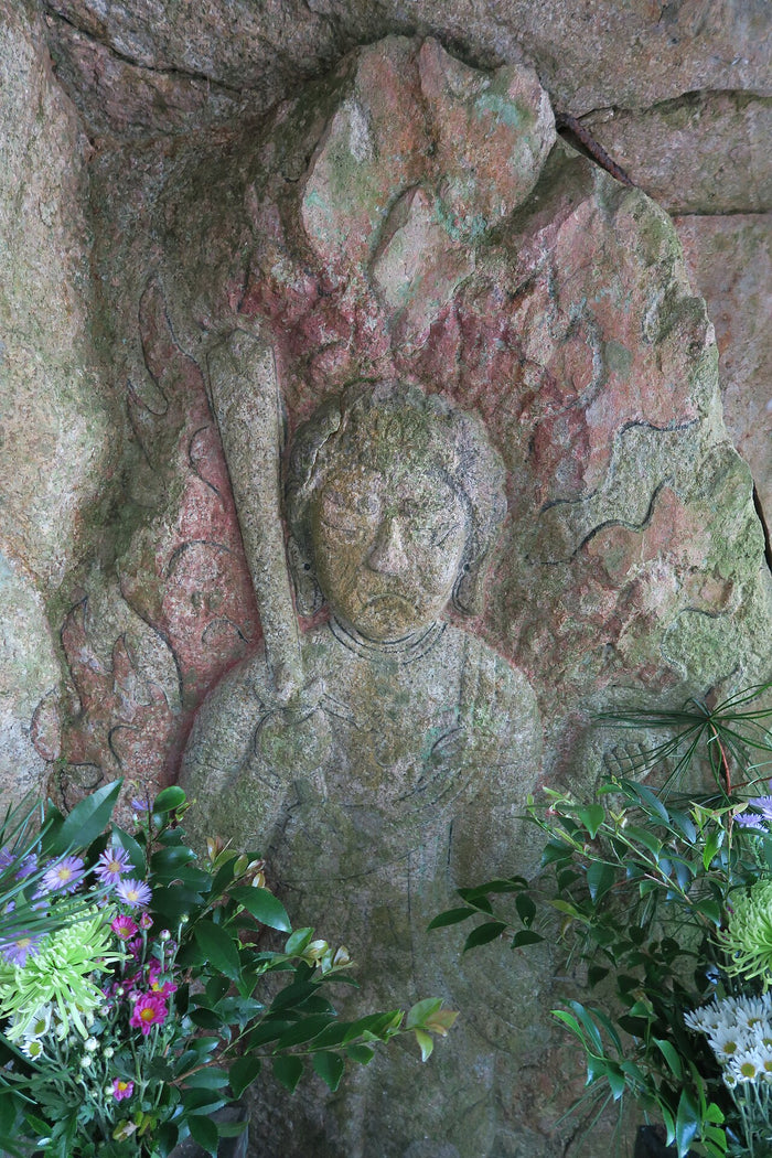 Katazoe rock-carved Fudō Myōō with traces of red flame halo, showing the deity's presence in Japanese mountain-rock worship.