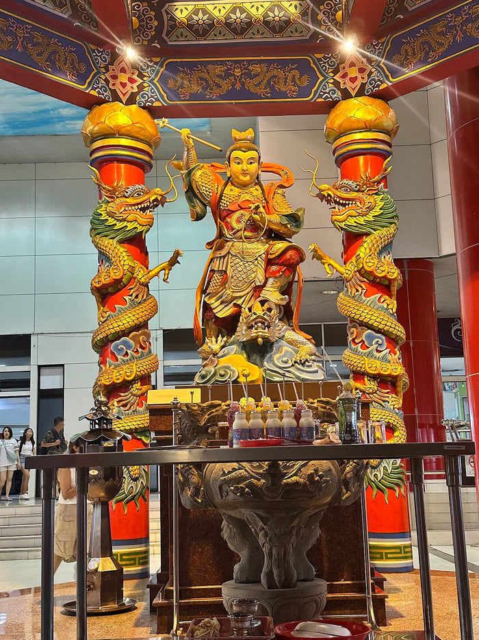 Statue of Nezha in armour at the Nezha Pavilion Temple outside Palladium Mall, flanked by dragon-entwined pillars.