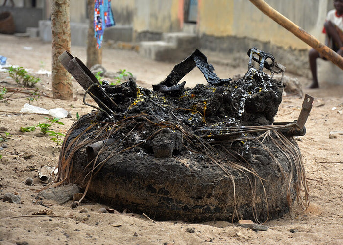 Ogun shrine, 2025: a mound with scrap iron pieces and palm fronds, reflecting Ògún's association with iron and metalwork.