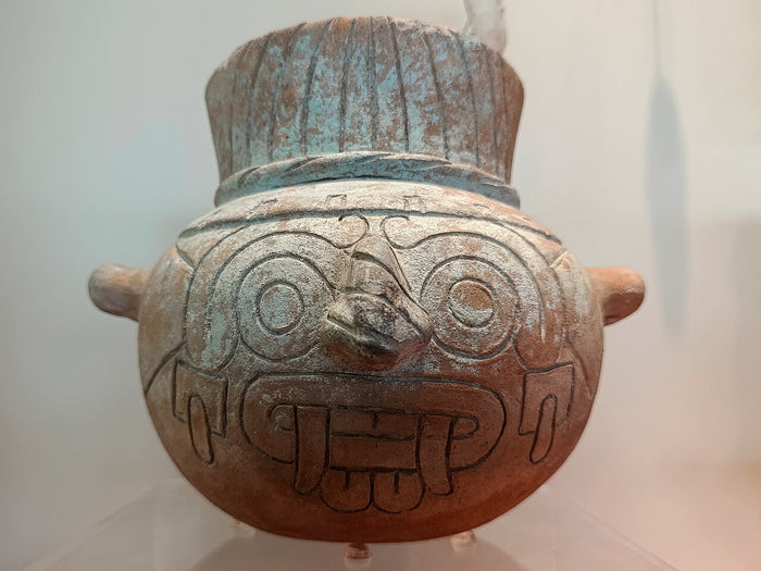 Mexica ceramic olla of Tláloc, with his goggle eyes, fanged mouth and headdress; shown in a museum, 2026.