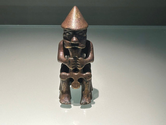 Small seated bronze figure of a bearded, pointed-capped god gripping his hammer, matching Thor's iconography.