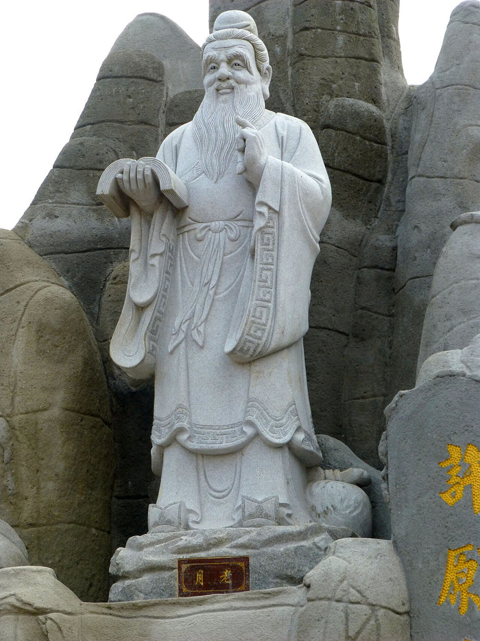 Stone statue of Yue Lao at Ping Sien Si, labelled 月老. He is a bearded elder in scholar's robes holding a book.
