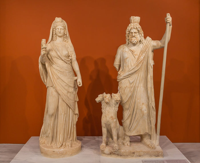 Marble statues of Pluto-Serapis with Cerberus and Persephone-Isis, Heraklion museum, showing her as consort of the underworld ruler.
