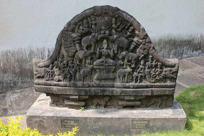 Stone Gajalakshmi relief: Lakshmi seated on a lotus while elephants pour water over her.