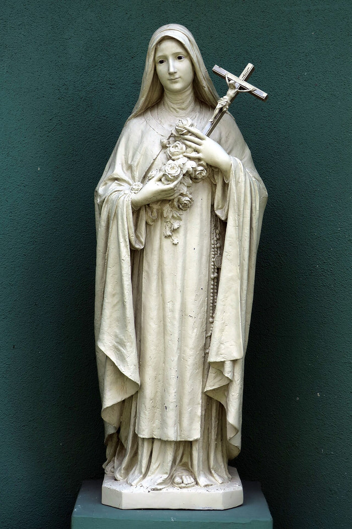 Statue of Thérèse holding roses and a crucifix, her best-known attributes, at the Columbus, Ohio retreat center shrine chapel.
