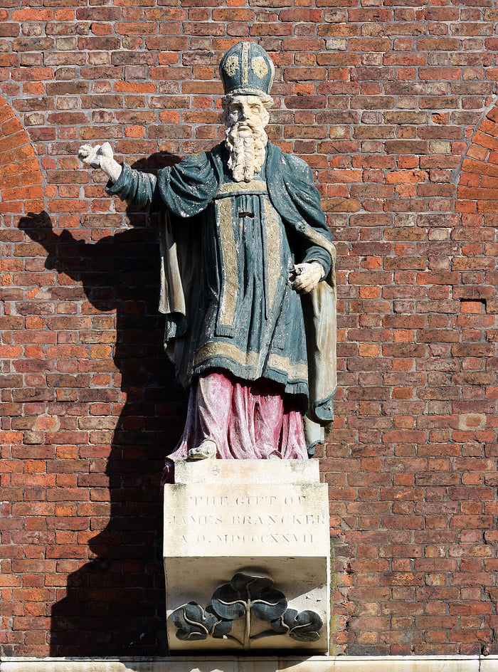 Statue of St Patrick in mitre and vestments, on a shamrock-carved plinth, at St Patrick's, Toxteth.
