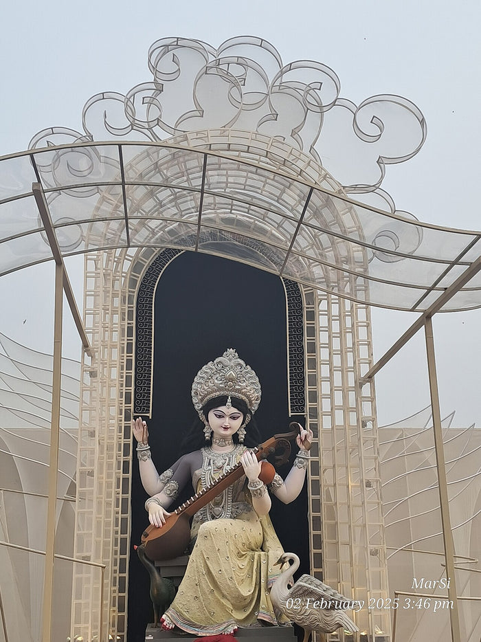 Large Saraswati image at Tala Prottoy pujo, 2025, holding a veena with a swan (hamsa) at her feet.