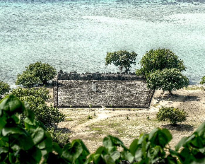 Aerial view of Taputapuātea marae on Raiatea, showing its walled stone platform beside the lagoon.