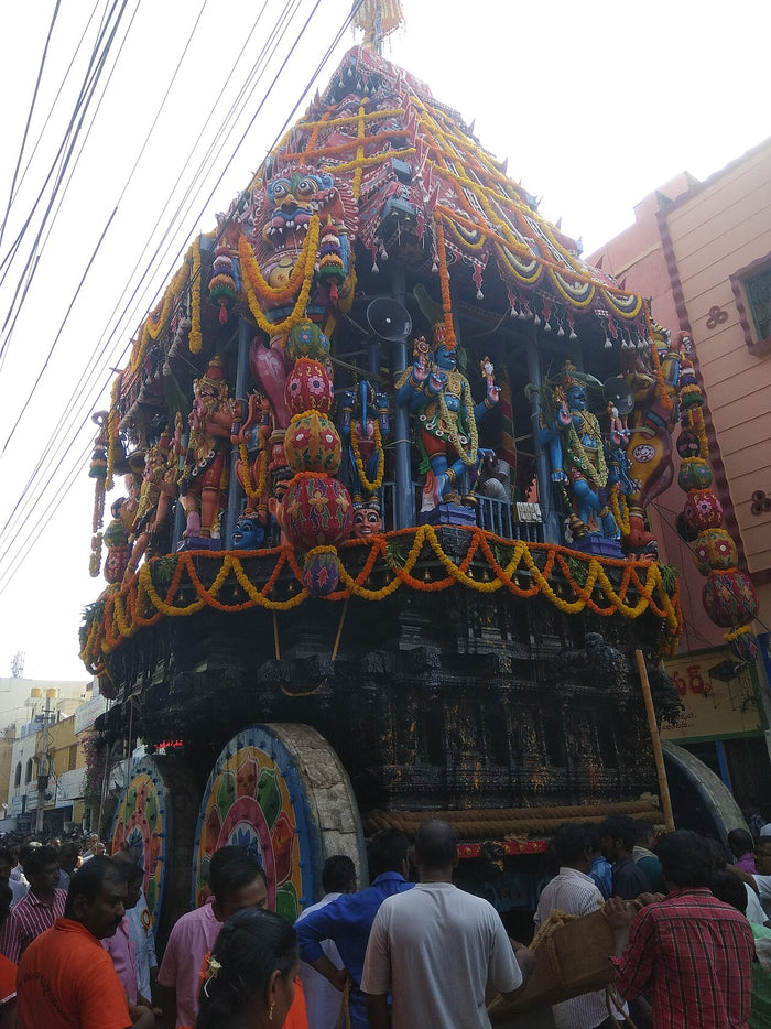 Decorated Tirupati temple chariot with colourful deity figures, used in processions honouring Venkateswara.