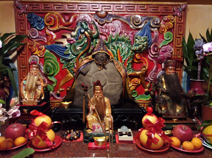 Altar with Tudi Gong at centre, attendant figures beside him, and offerings of fruit, in Beitou, Puding (2019).