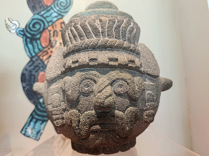 Carved stone Tláloc vessel in Mexica style, showing the god's ringed eyes and mouth band.