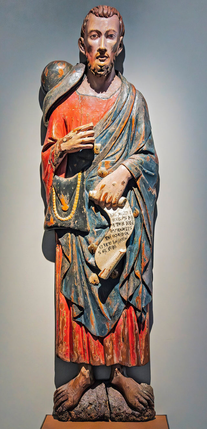 Painted wooden pilgrim figure of the saint, 14th century, with scallop shells on his cloak and a scroll.