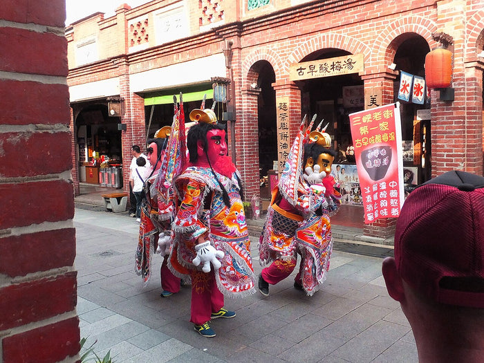 Costumed Third Prince (Nezha) figures parading in a street in Taiwan, part of folk-religion procession tradition.