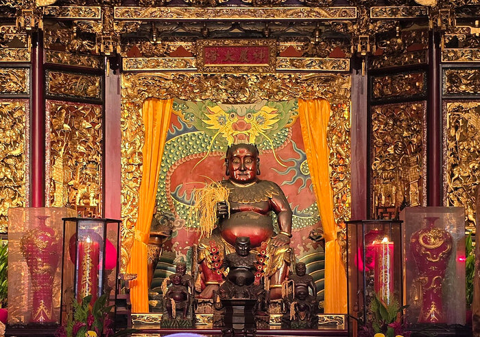 Shennong Dadi enshrined at Bao'an Temple in Dalongdong, Taipei, holding grain before a dragon backdrop.