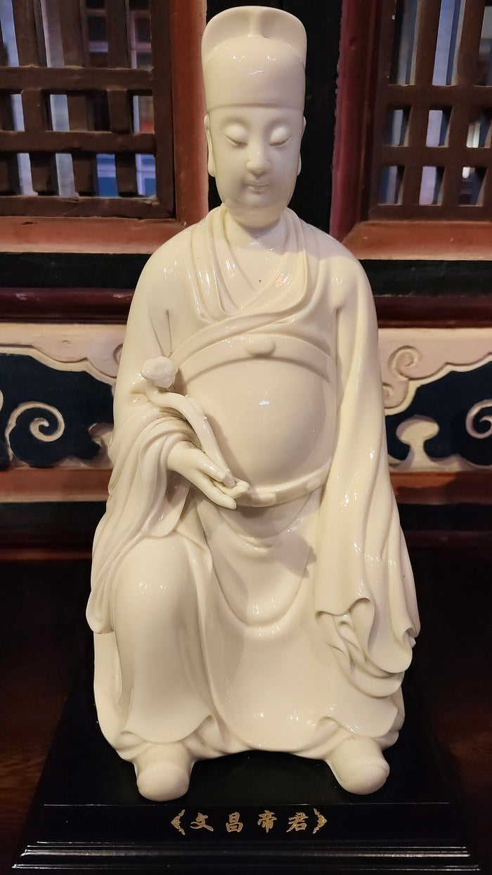 White porcelain figure of Wenchang Dijun in scholar's robes and cap, holding a ruyi-like scepter, labeled 文昌帝君.
