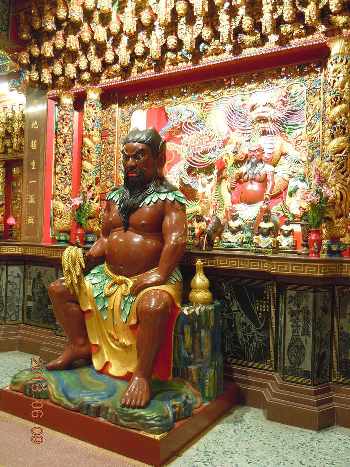 Seated Shennong statue, 2013: horned, bearded, wearing a leaf garment and holding grain, reflecting his legendary herb-tasting and farming image.