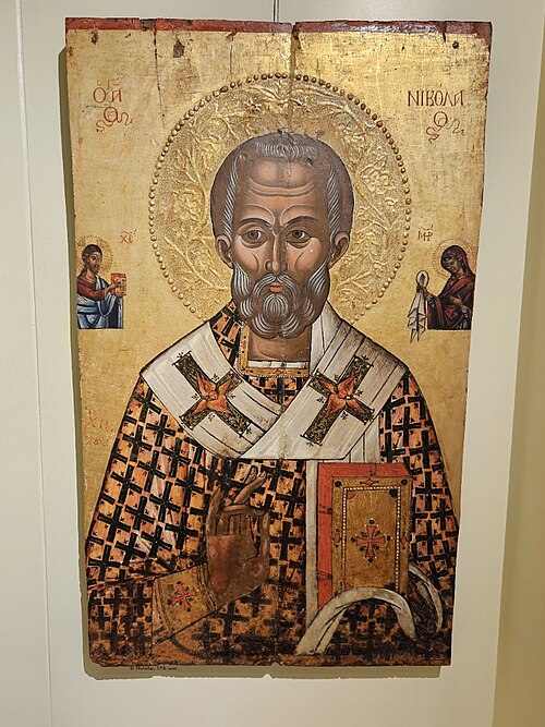 Saint Nicholas icon in the Antivouniotissa Museum, Corfu: Byzantine-tradition bishop with book, flanked by Christ and the Virgin.
