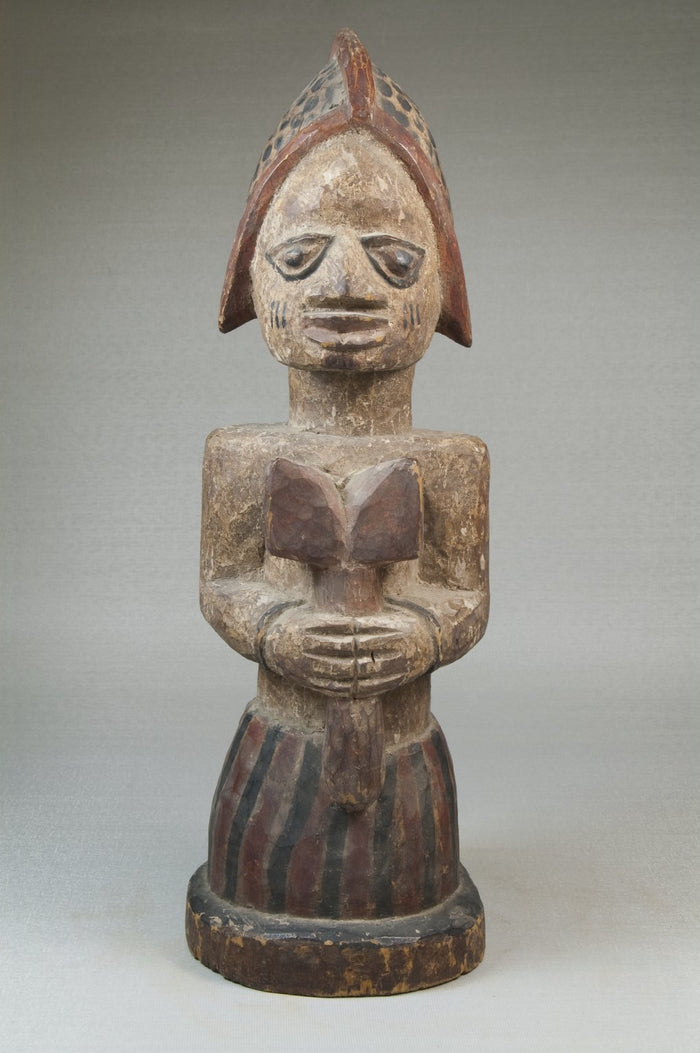 Yoruba carved figure of a Shango devotee holding an oshe, the double-headed axe staff that is Ṣàngó's main emblem.