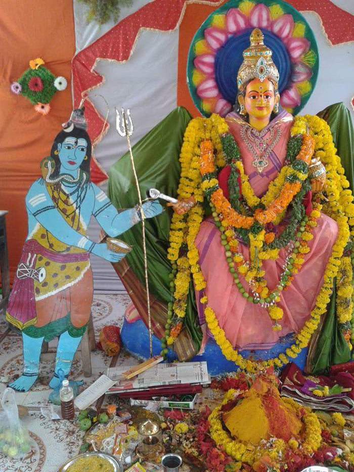 Annapurna Alamkaram at Chinalingala Dussera 2014: seated goddess adorned with flowers, with a cut-out Shiva holding a begging bowl.