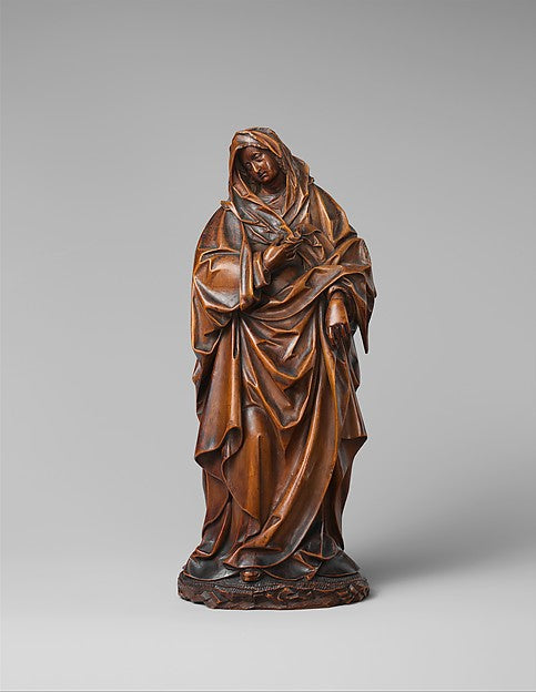 Carved wooden Virgin Mary, ca. 1560, in heavy draped mantle and veil, head bowed in sorrow.