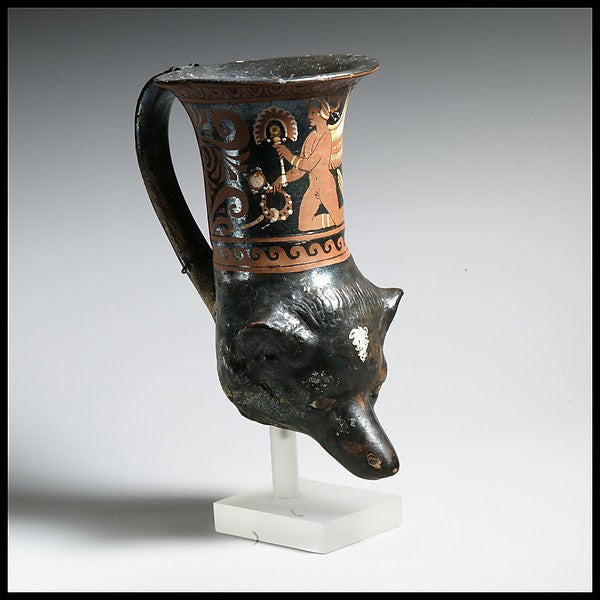 Apulian dog's-head rhyton, 350–300 BCE, with winged Eros holding a ritual object among adornments.