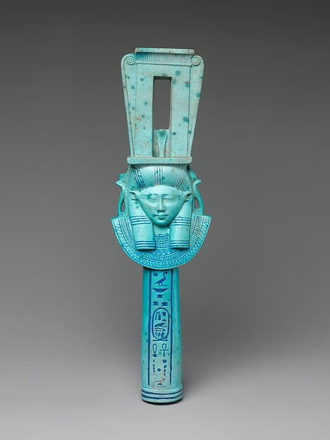 Faience sistrum with Hathor's face and cow ears, inscribed for Ptolemy I; the sistrum was her sacred rattle.