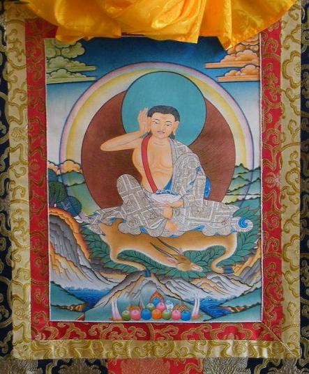 Modern thangka showing his standard iconography: cotton robe, hand cupped to ear, bowl in hand, and an animal beneath him.