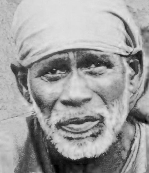 Close portrait of Shirdi Sai Baba, showing his white beard and head-cloth, a widely reproduced devotional image.