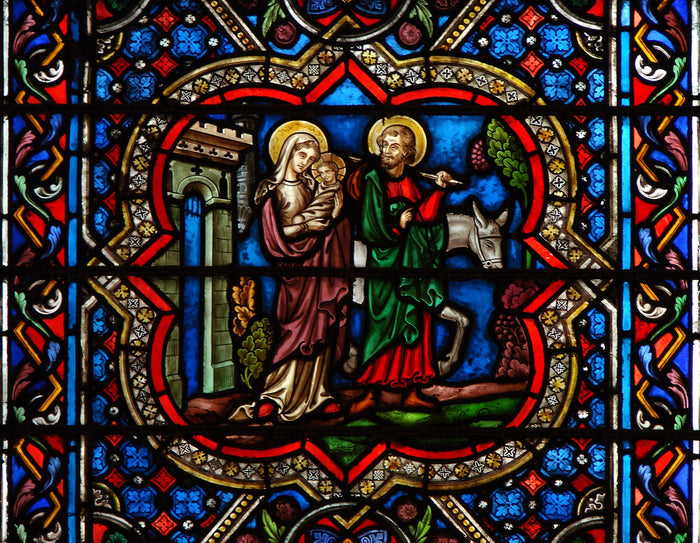 Stained glass at Notre-Dame de Paris showing the Flight into Egypt: haloed Mary with Child, Joseph and donkey.
